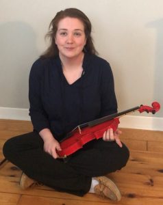 Adult on floor with violin in her lap