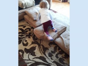 Child on couch cushions