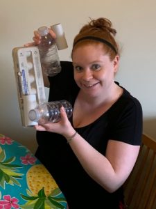 Adult holding empty egg carton and water bottles