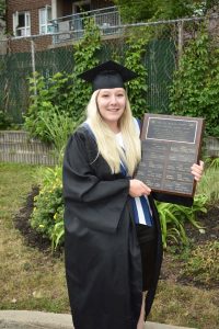 Young mother and graduate holding award